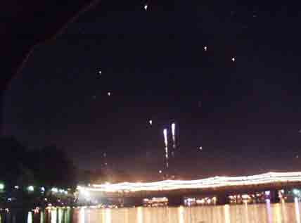 [写真]ピン川川岸から次々に上がる花火と熱気球